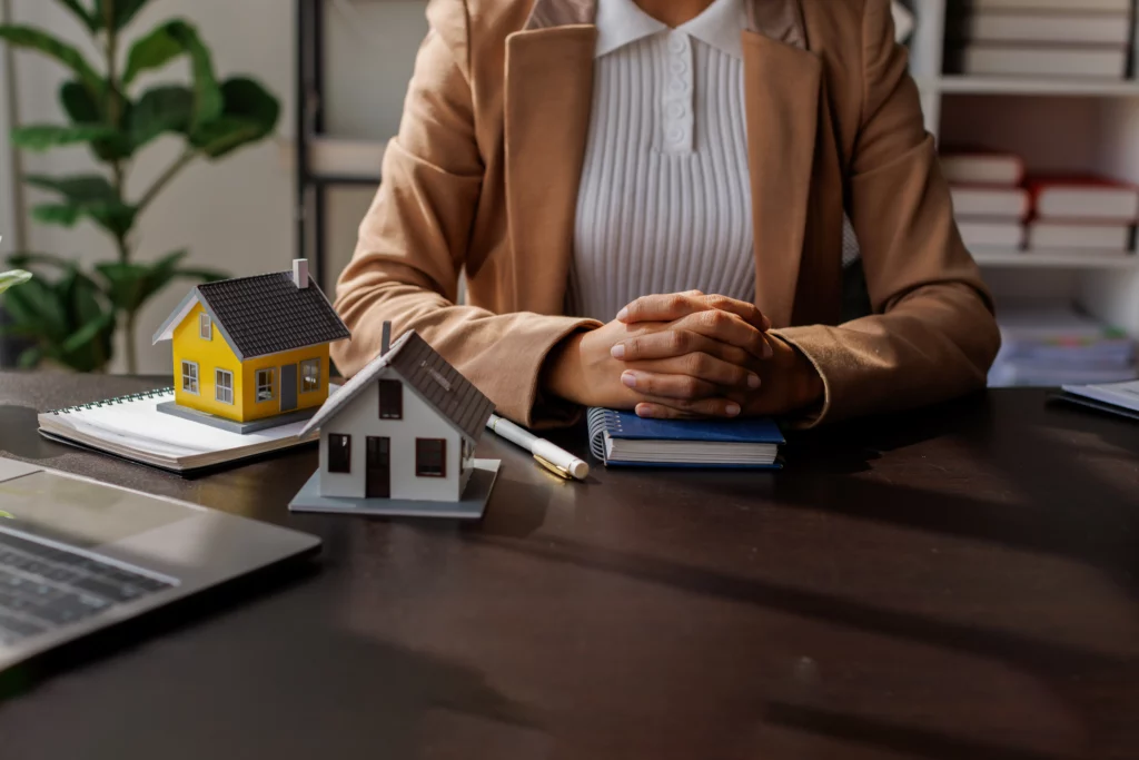 Conseillère avec maquettes de maisons, secteur immobilier accompagné par Habyss